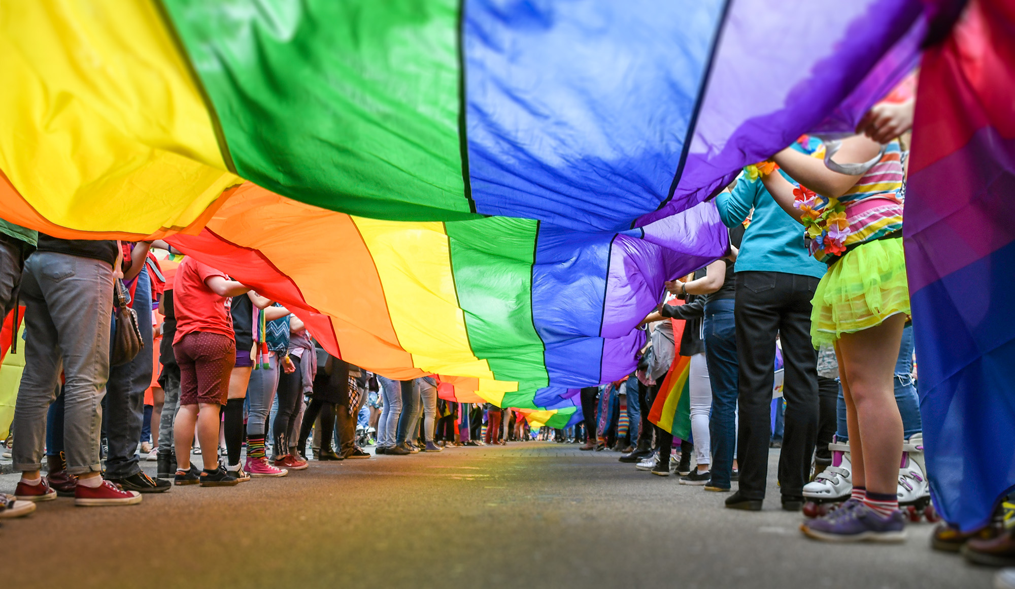 people holding large pride flag